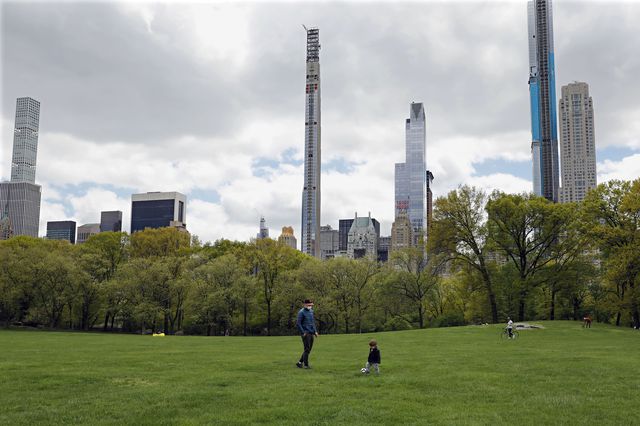 A father kicks around soccer ball with his young son in Central Park's Sheep Meadow in New York.